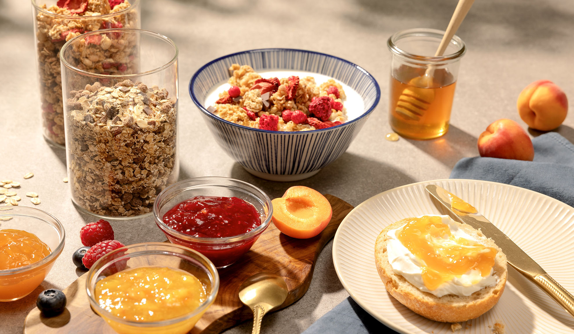 Petit-déjeuner avec granola, miel, confiture et fruits frais.