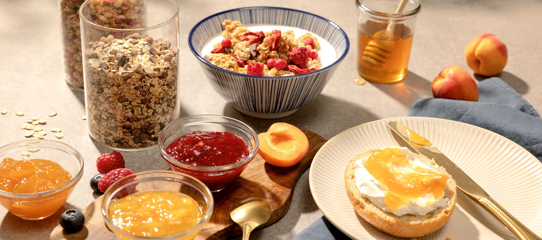 Petit-déjeuner avec muesli, confiture, miel et pain au fromage frais et confiture.