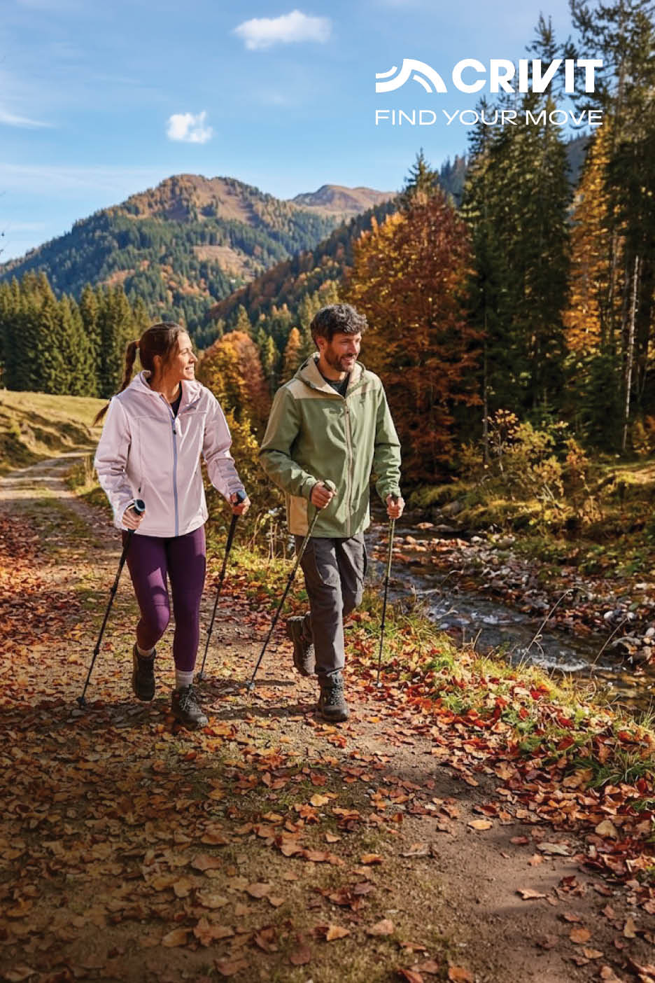 Een man en vrouw wandelen met wandelstokken over een herfstpad in de bergen.