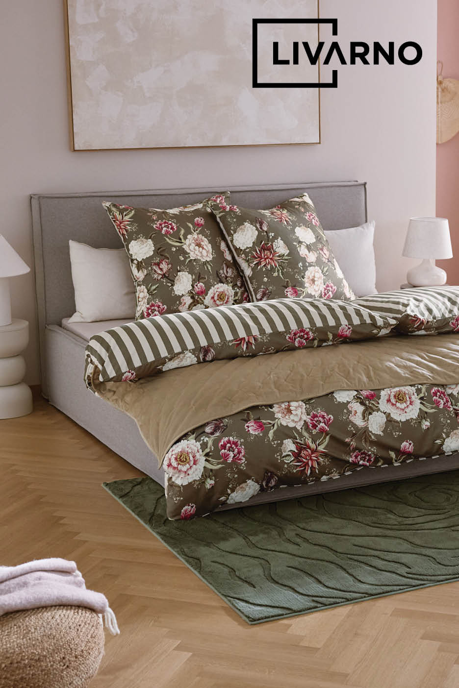 Tweepersoonsbed opgemaakt met bloemig groen beddengoed op een groen vloerkleed.