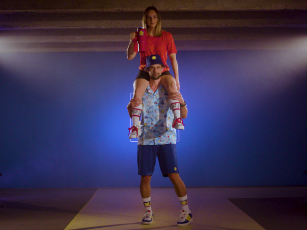 Femme sur les épaules d'un homme, boissons et vêtements de sport.