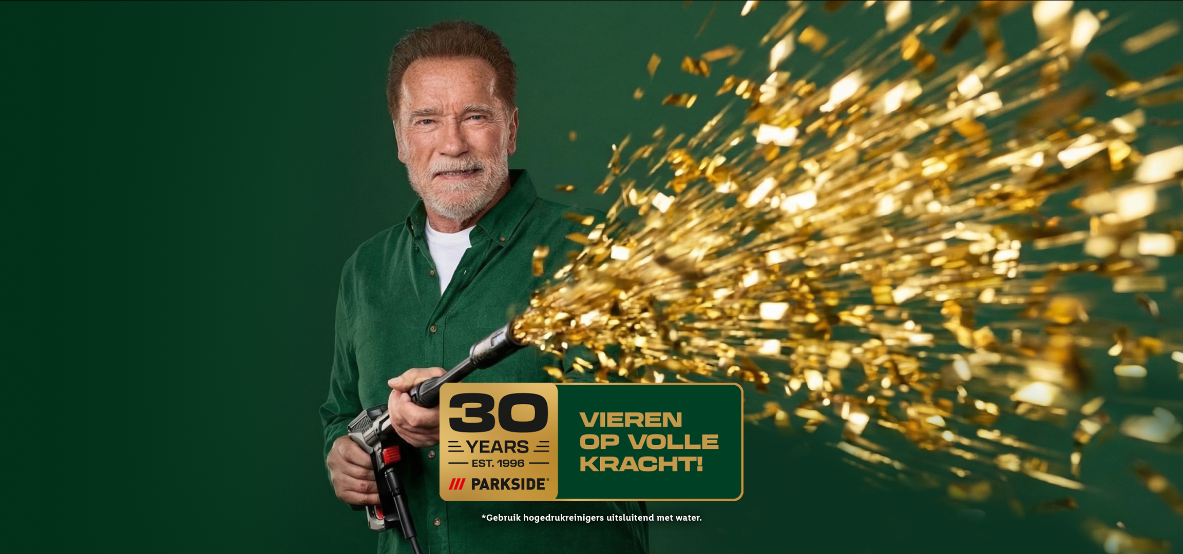 Man met baard spuit gouden confetti uit een hogedrukreiniger, viert 30 jaar.