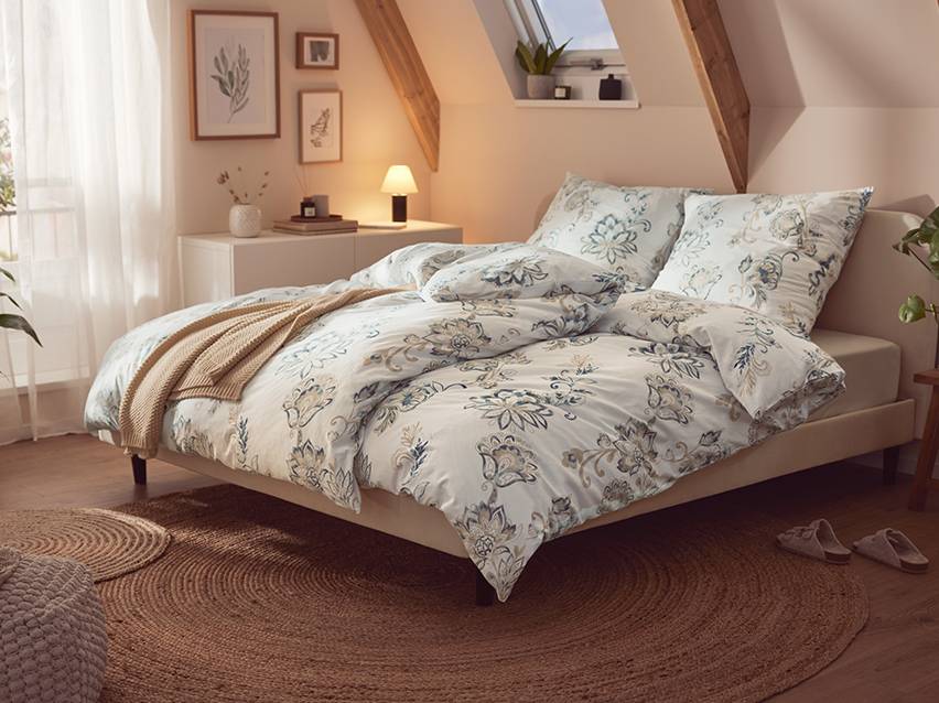 Parure de lit fleurie dans une chambre.