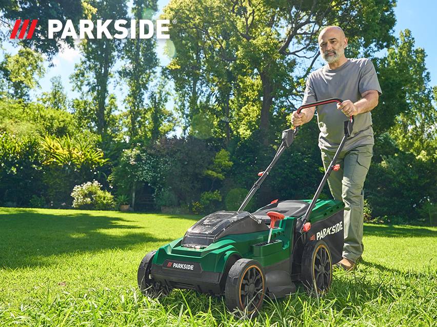 Un homme utilise une tondeuse à gazon Parkside.