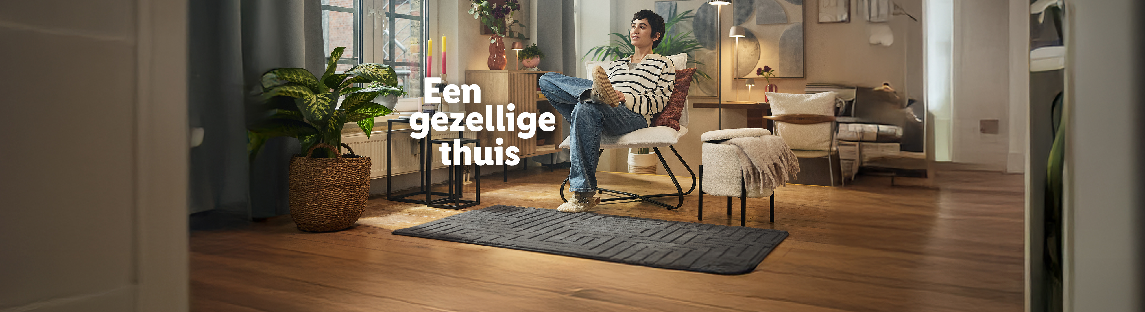 Een vrouw leest in een gezellige woonkamer met een vloerkleed en planten.