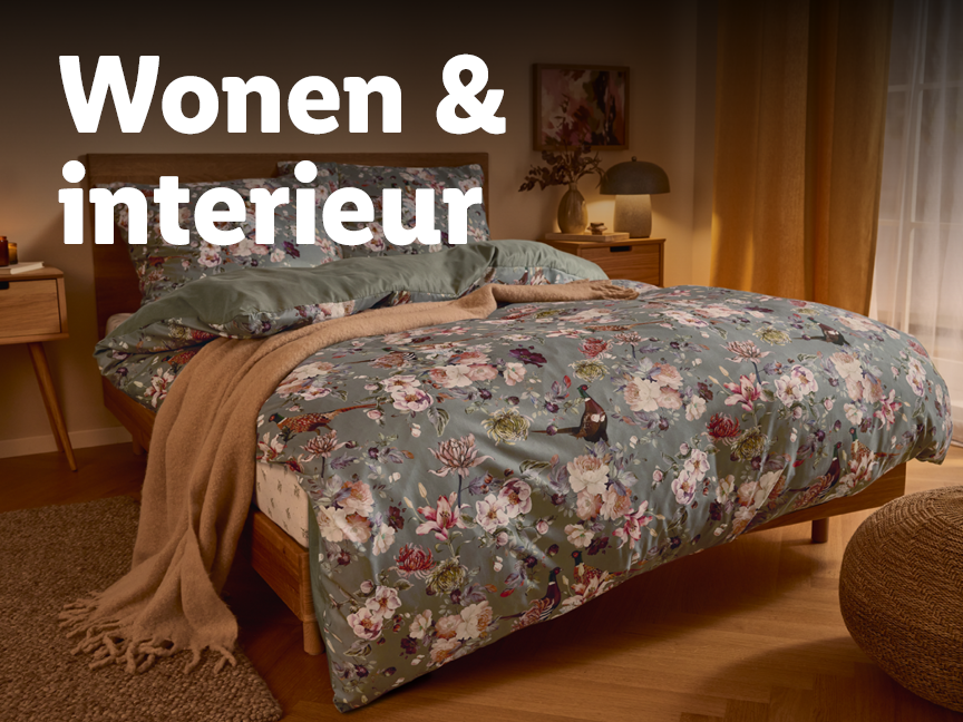 Slaapkamer met houten bed, bloemig beddengoed en nachtkastje.