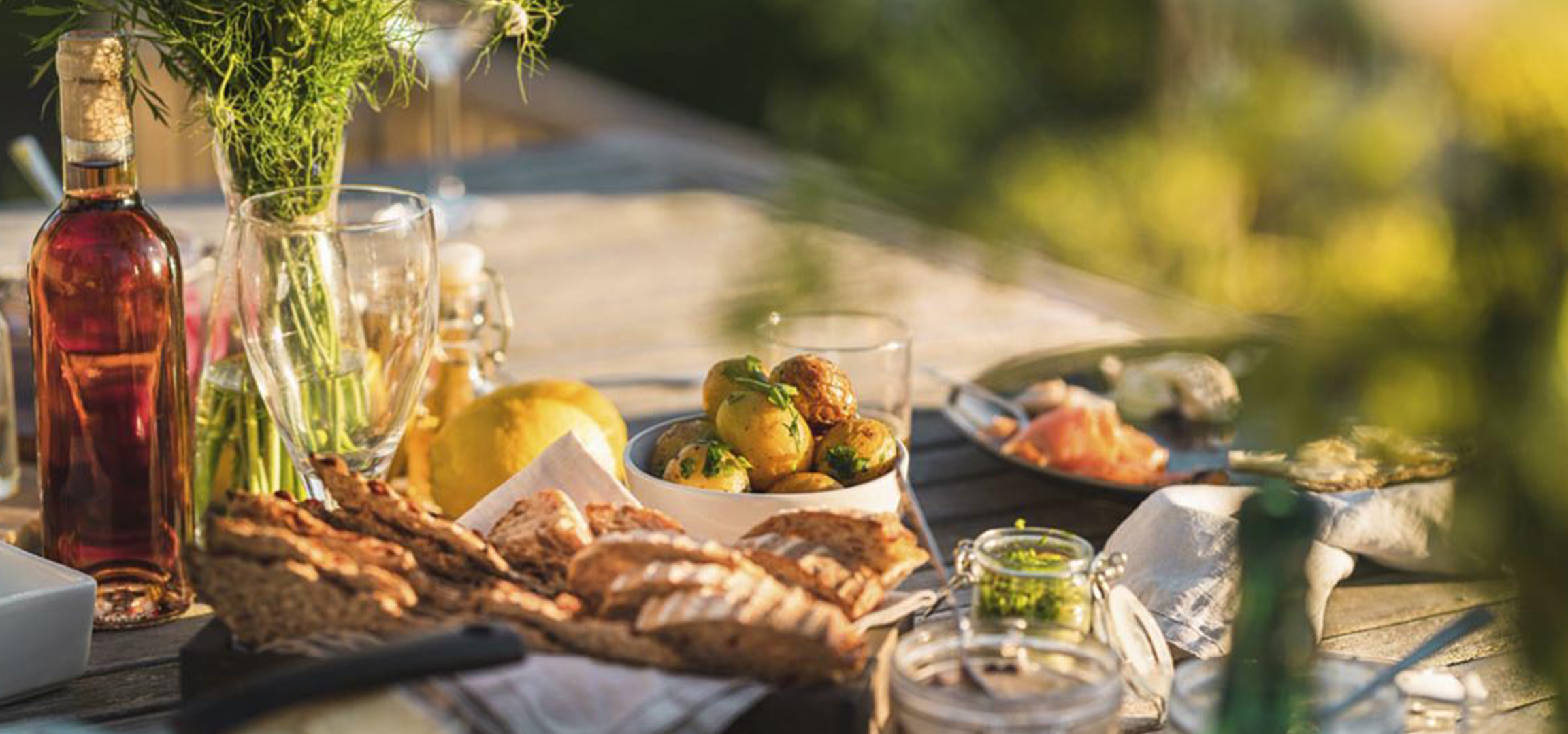 Un repas en plein air avec des pommes de terre nouvelles, du pain et du saumon.