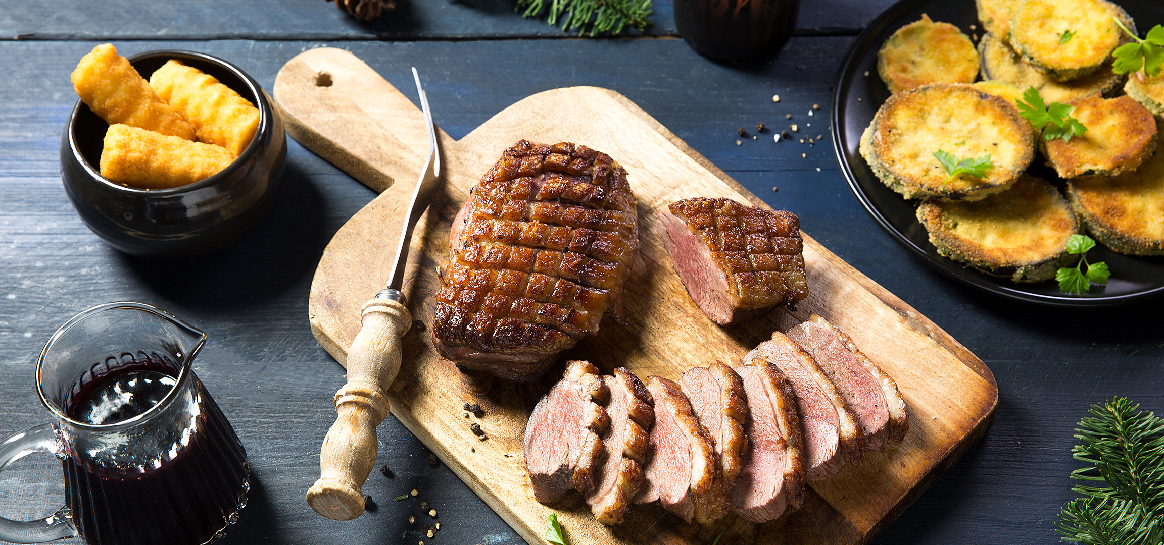Gesneden gebraden eend op een houten snijplank, met rode wijn en gefrituurde groenten.