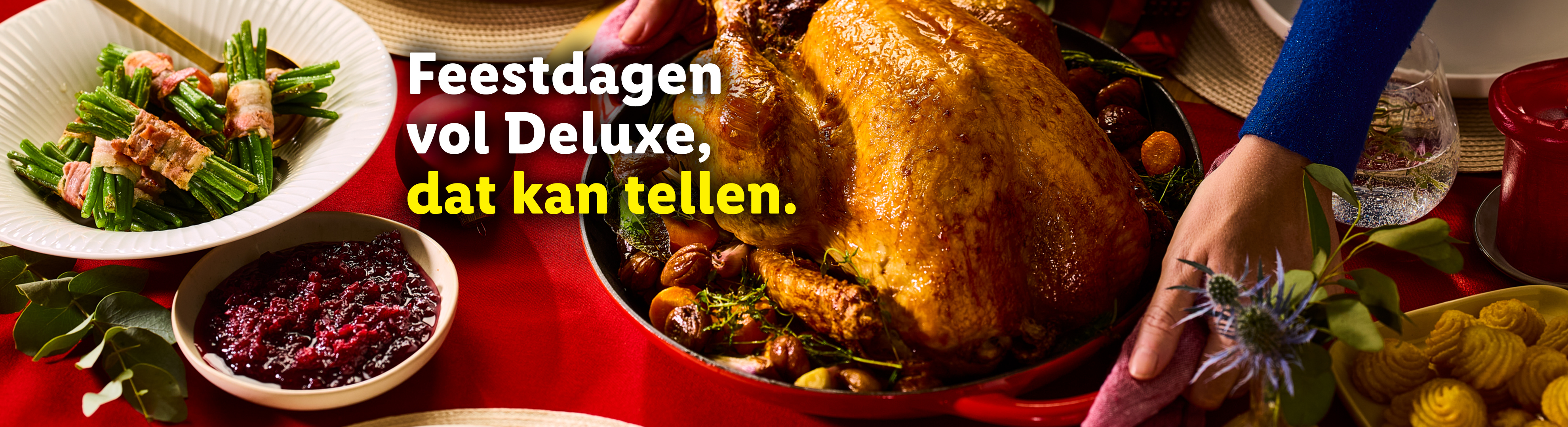 Gebraden kalkoen, sperziebonen met spek en cranberrysaus op een feestelijke tafel.