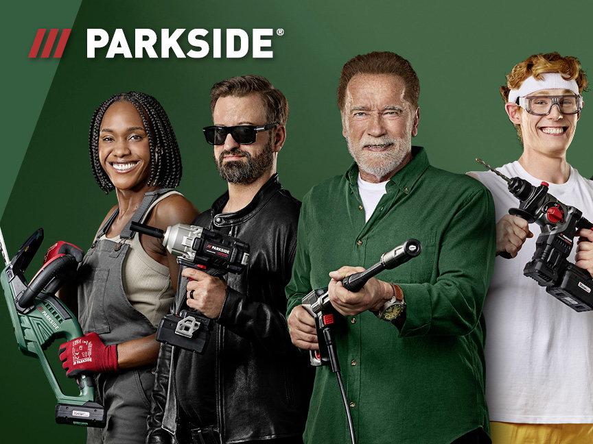 Vier mensen, waaronder Arnold Schwarzenegger, poseren met Parkside elektrisch gereedschap.