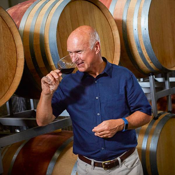 Man proeft wijn in een wijnkelder met houten vaten.