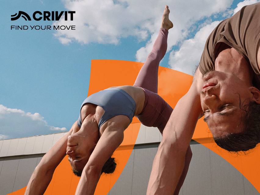 Twee mensen die buiten yoga doen, gekleed in sportkleding.