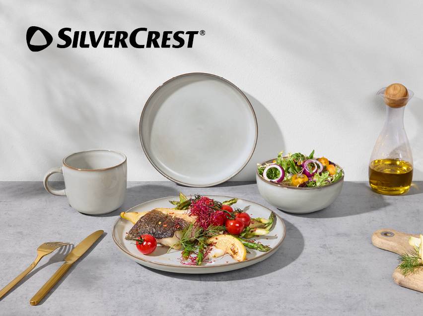 Keramisch servies met een vismaaltijd, salade en olijfolie.