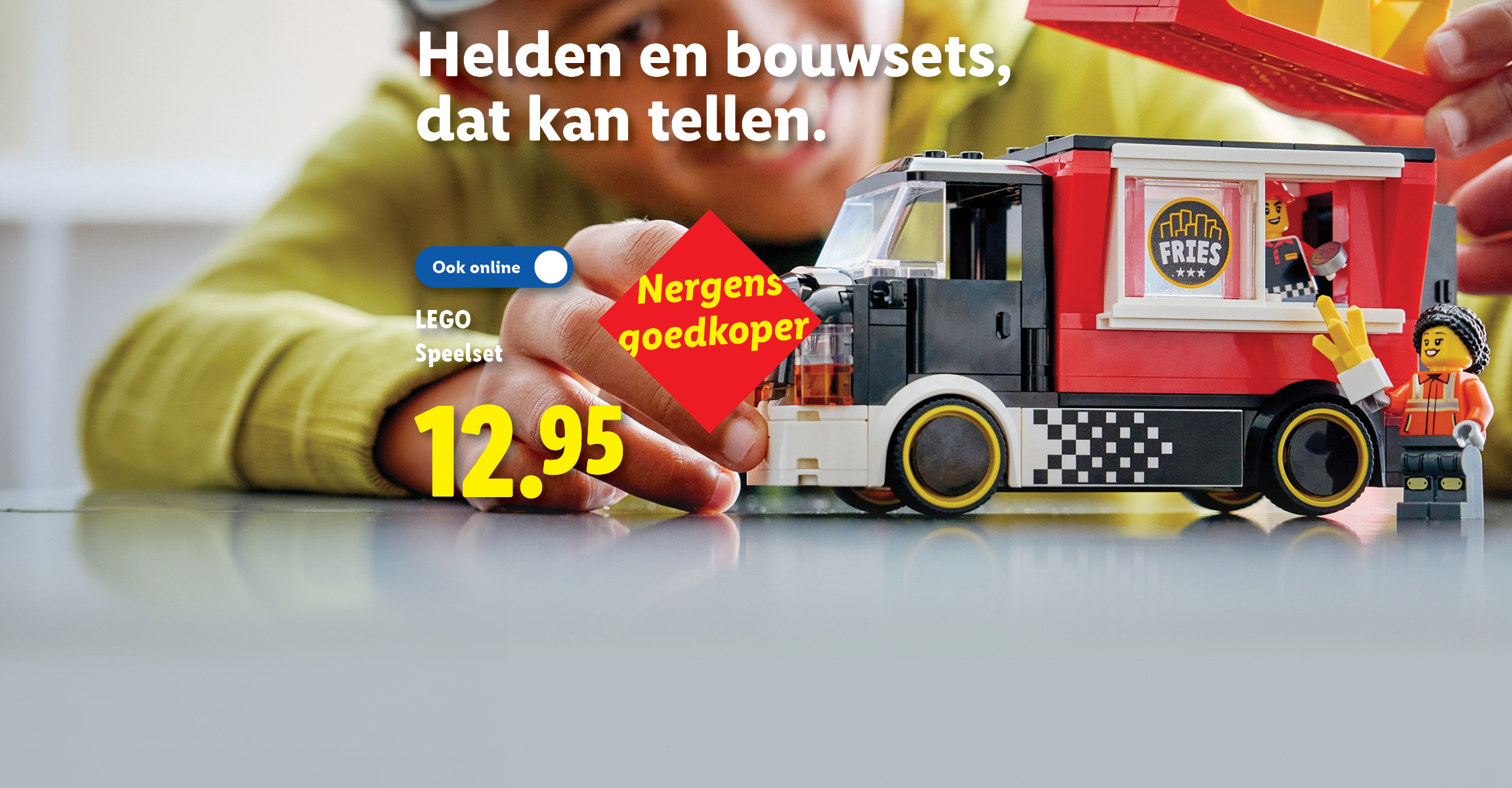 Sfeerbeeld van een kind dat speelt met een LEGO Speelset van een frietwagen, met de tekst: Helden en bouwsets, dat kan tellen. Nergens goedkoper. Ook online. 12.95.