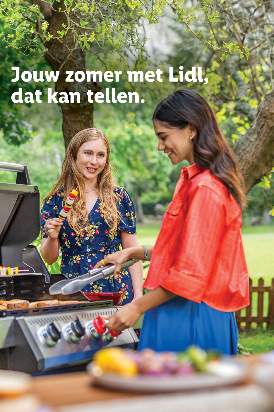 Twee lachende vrouwen barbecueën buiten, met groentespiesjes en vlees op de grill.