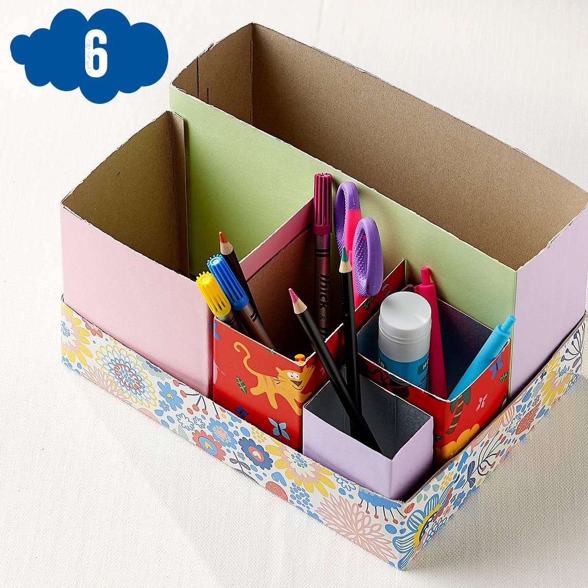 Kartonnen bureau-organizer met stiften, potloden en lijm.