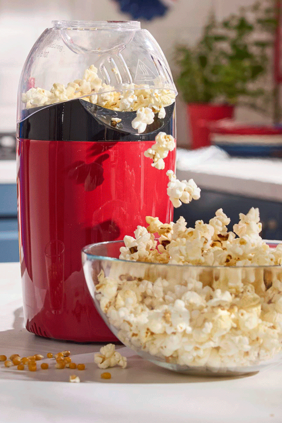 Rode popcornmachine vult een grote kom met vers gepofte popcorn.