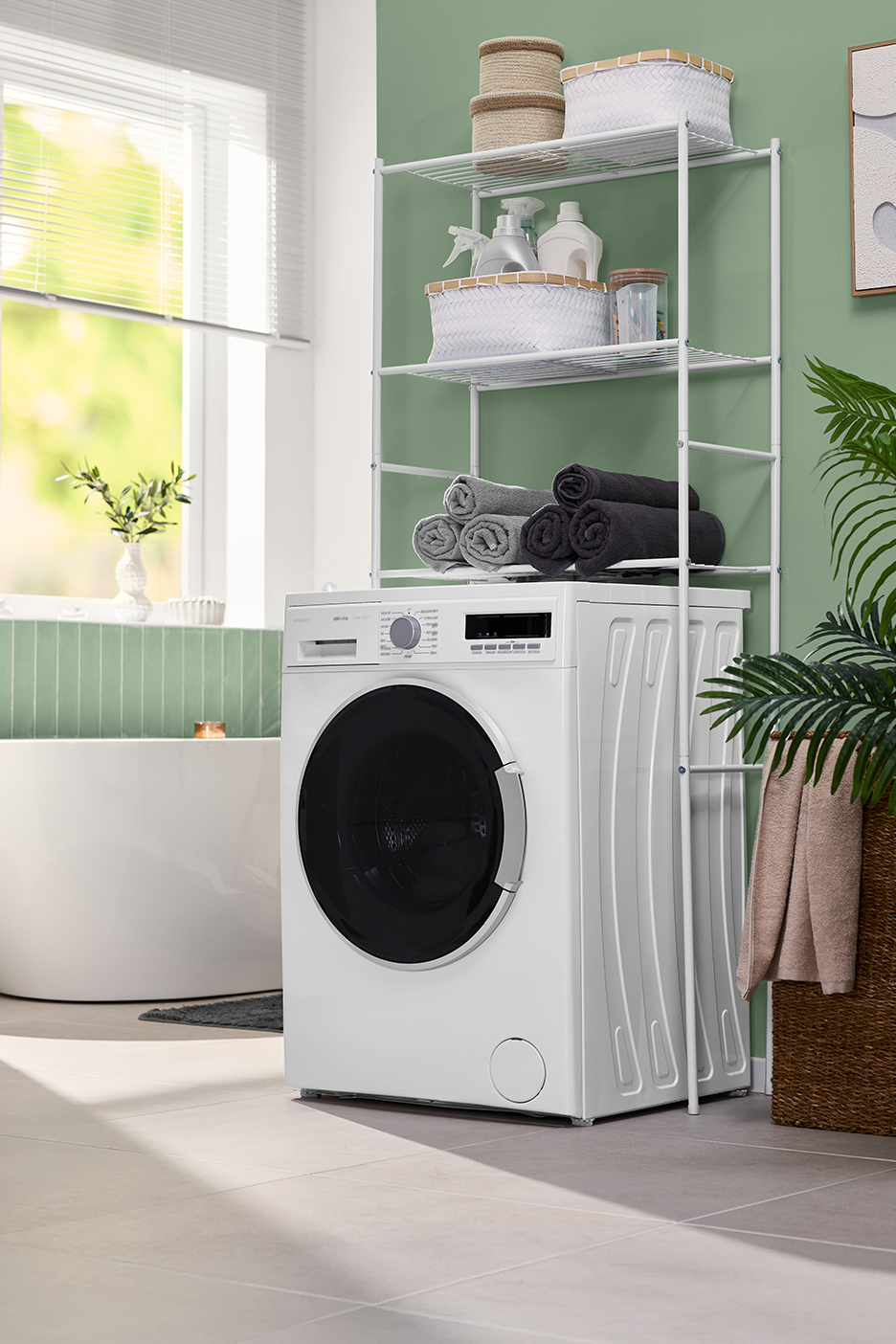 Wasmachine met wit metalen rek erboven, met handdoeken en wasmiddelen.