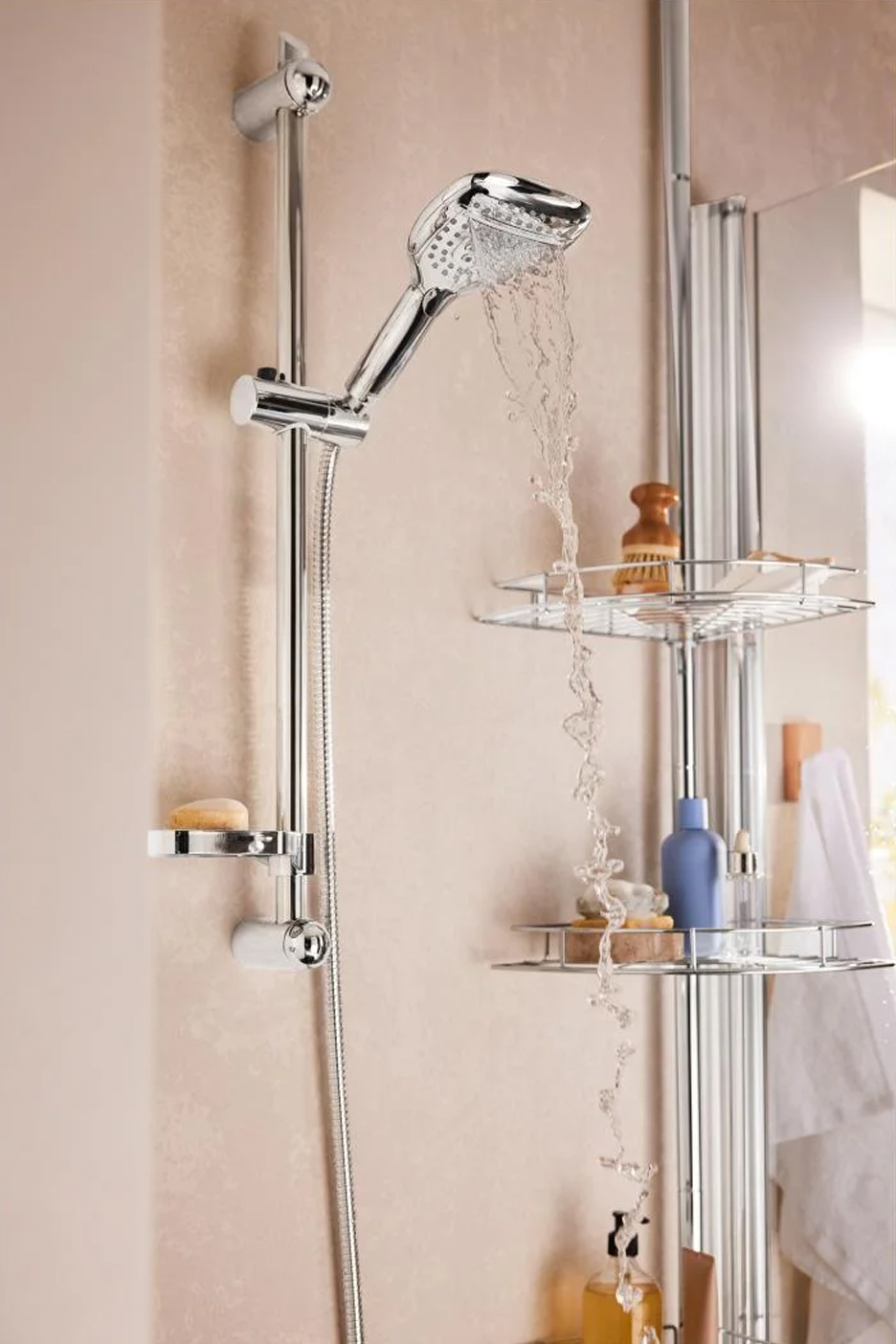 Chromen doucheset met handdouche, glijstang en zeepbakje, water stroomt in een doucherek.