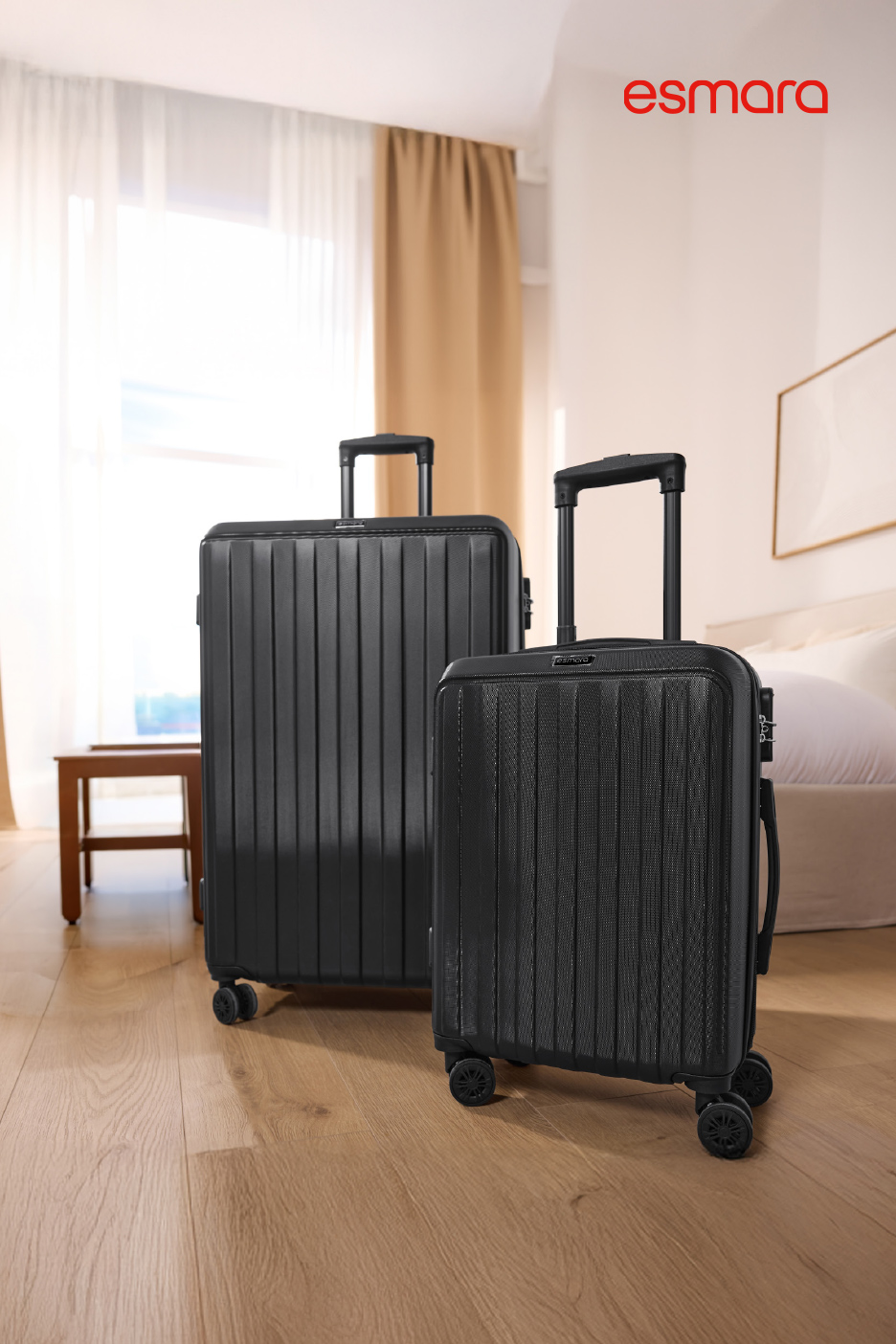 Twee zwarte koffers met wieltjes op een houten vloer in een lichte kamer.