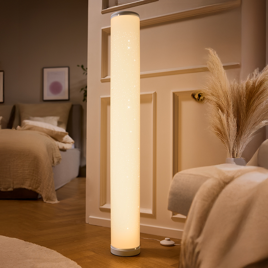 Witte cilindervormige vloerlamp met sterrenpatroon, verlicht een slaapkamer.