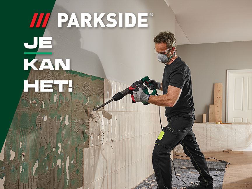 Een man gebruikt een Parkside sloophamer om tegels te verwijderen.