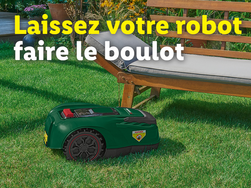 Un robot tondeuse Gardena tond l'herbe tandis qu'un transat en bois est à côté.