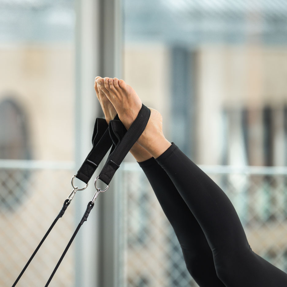 Persoon die Pilates doet met voeten in banden.