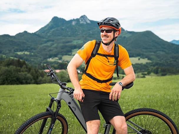 E-bike en fietser in een berglandschap.