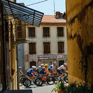 Cyclistes à vélo passant devant une boulangerie par une journée ensoleillée.