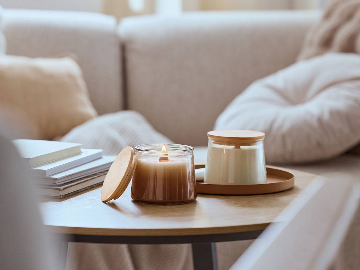Twee geurkaarsen op een houten salontafel in een woonkamer