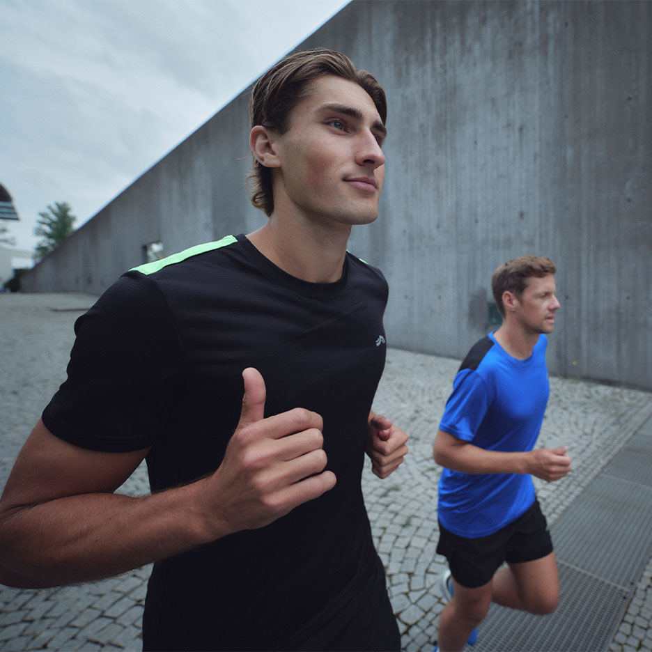 Twee mannen in Crivit sportkleding rennen buiten.