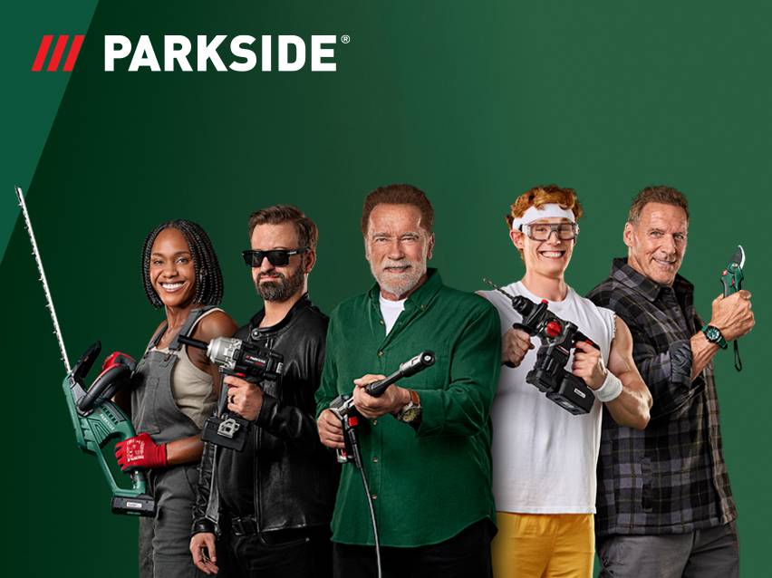 Een groep lachende mensen met diverse elektrische gereedschappen en tuingereedschap.