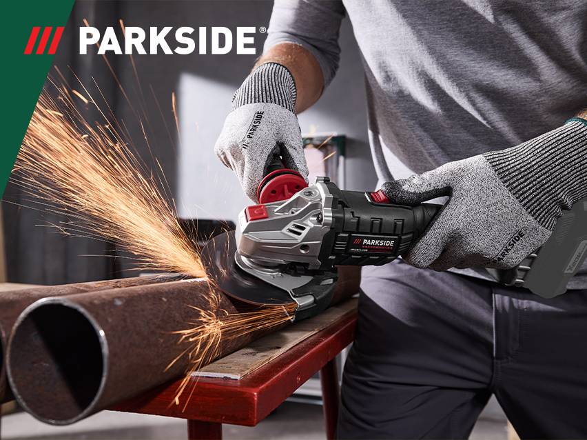 Man slijpt metalen buizen met een haakse slijper, vonken vliegen in het rond.