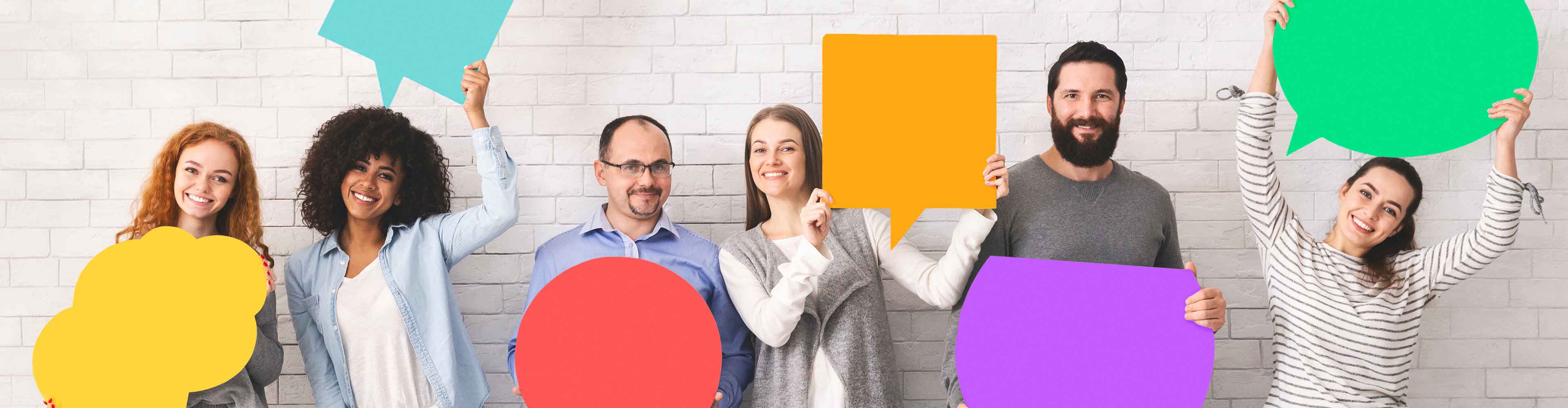 Mensen houden kleurrijke spraakbellen vast.