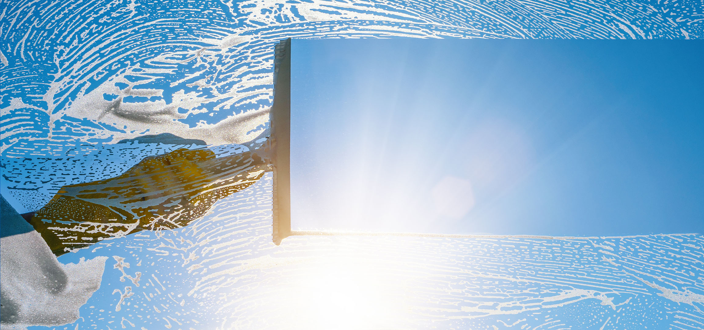 Ramen wassen met zeepsop tegen een blauwe lucht.