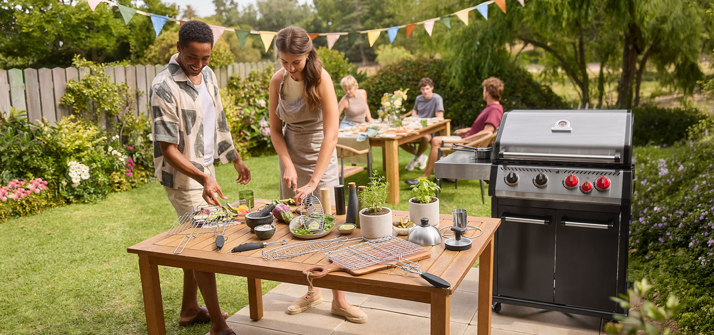 Mensen bereiden eten op een barbecue in de tuin, met gasbarbecue en tafel.
