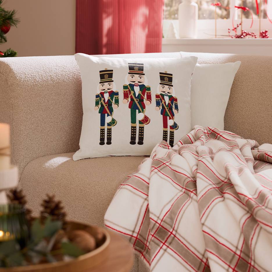 Bank met Notenkraker kerstkussen en plaid.
