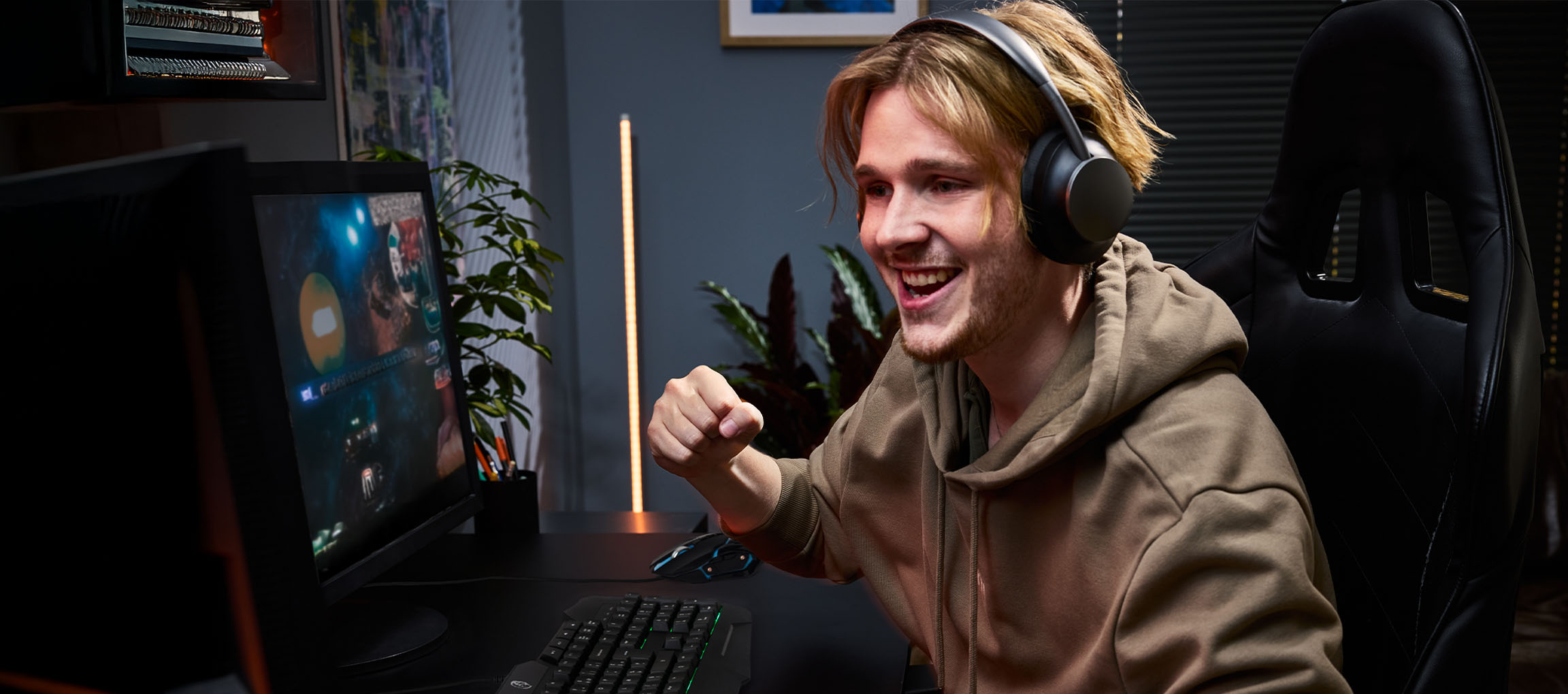 Jeune homme avec un casque jouant à des jeux vidéo avec un clavier et une souris de jeu