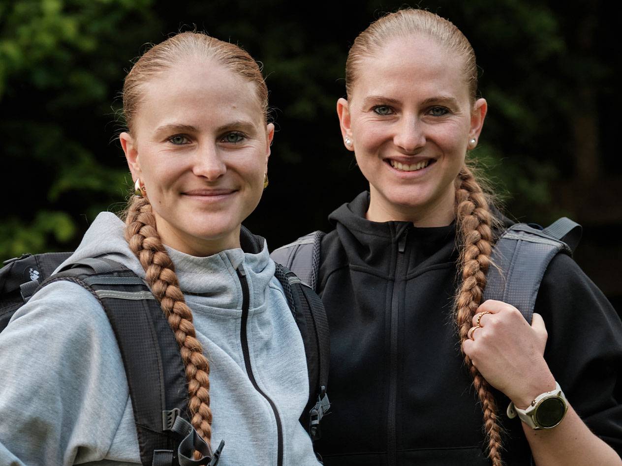 Deux femmes avec des sacs à dos se tiennent ensemble.